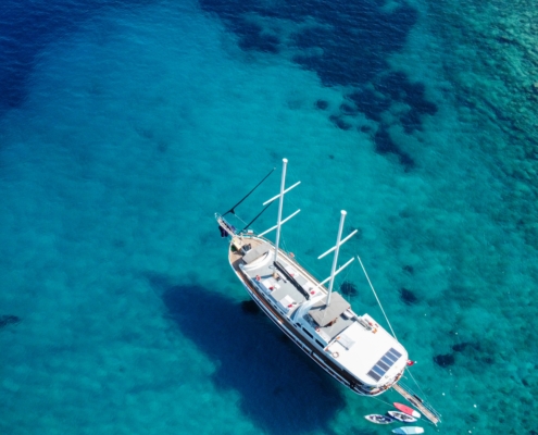 Aerial view of a gulet anchored during the Fethiye to Gocek and Back cruise, with guests swimming in a circle formation in the turquoise sea