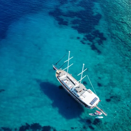 Aerial view of a gulet anchored during the Fethiye to Gocek and Back cruise, with guests swimming in a circle formation in the turquoise sea
