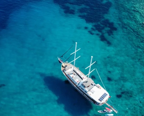 Aerial view of a gulet anchored during the Fethiye to Gocek and Back cruise, with guests swimming in a circle formation in the turquoise sea