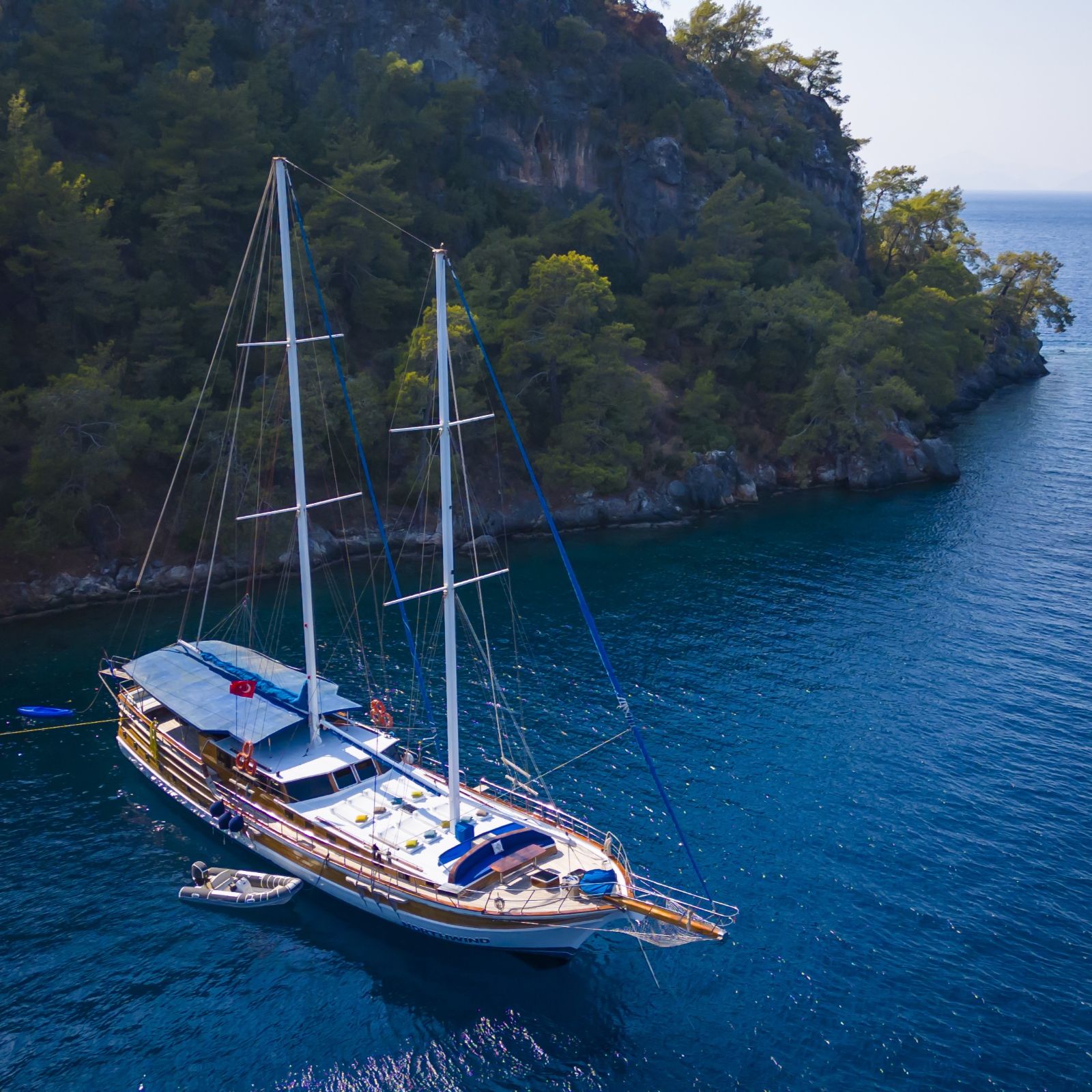 Traditional gulet anchored in a secluded bay surrounded by pine trees during the Fethiye to Olympos gulet cruise
