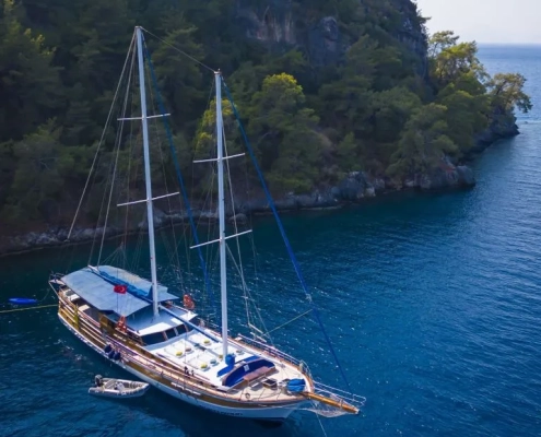 Traditional gulet anchored in a secluded bay surrounded by pine trees during the Fethiye to Olympos gulet cruise