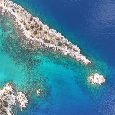 Aerial view of rocky coastline and turquoise waters along the Olympos to Fethiye and Back gulet cruise route, showcasing natural beauty from above