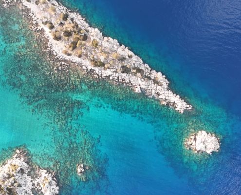 Aerial view of rocky coastline and turquoise waters along the Olympos to Fethiye and Back gulet cruise route, showcasing natural beauty from above