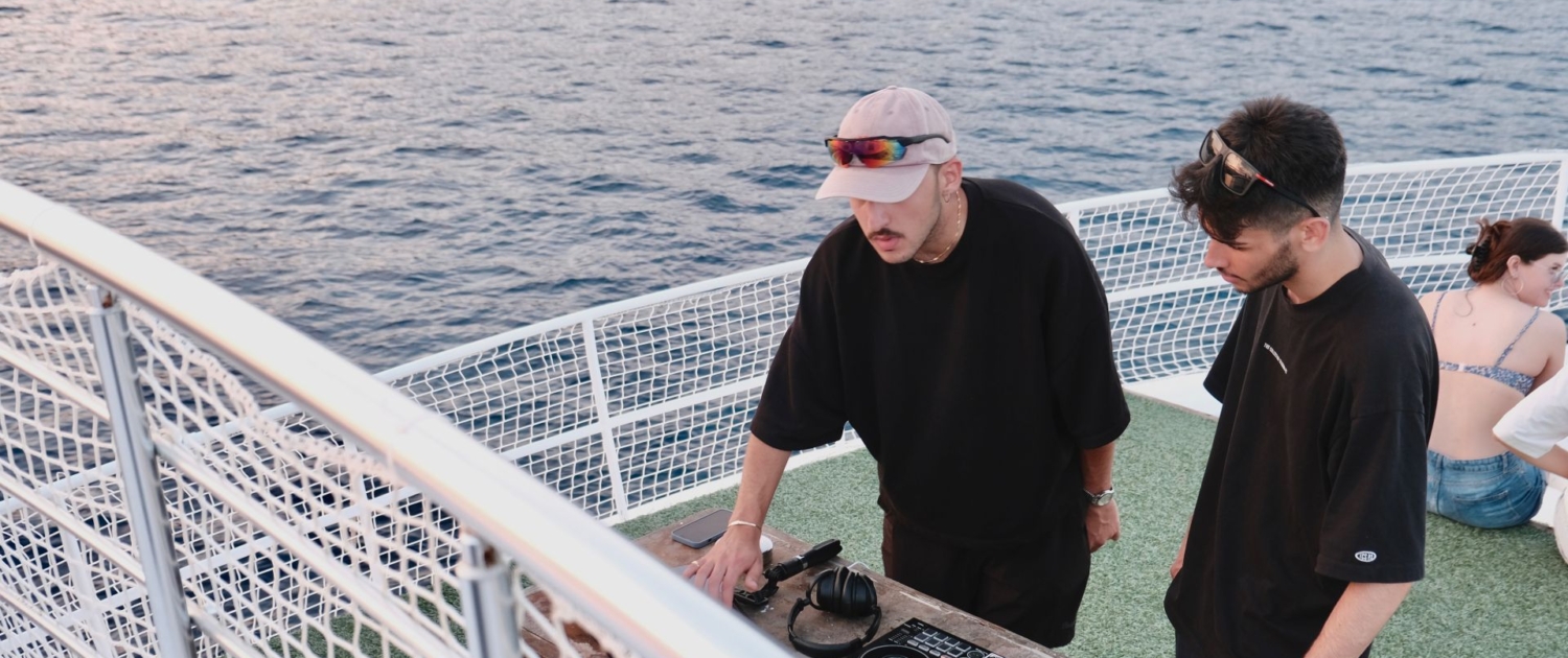 DJ setting up music equipment on the deck of a gulet during a Sail Turkey party cruise on the Mediterranean