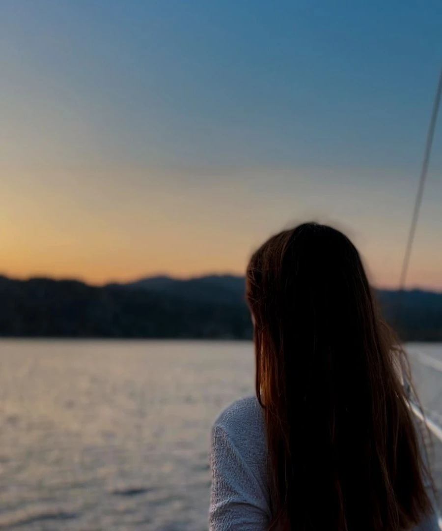 Woman enjoying a peaceful sunset on a private Turkish gulet charter – sailing along the coast of Turkey.